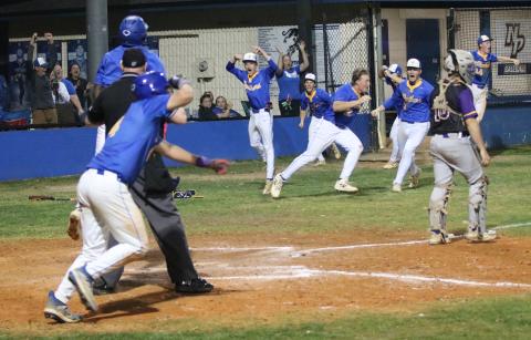 Newberry players pour out of the dugout after Desmond Taylor scored the game-winning run to defeat Columbia 12-11 on Tuesday. (JORDAN KROEGER/Lake City Reporter)