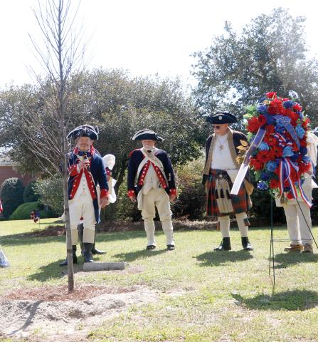 Chris Washler, the president of the Florida State Society of the Sons of the American Revolution, stands with other SAR members behind the liberty tree that was dedicated Saturday at Heritage Park and Gardens in Live Oak. (JAMIE WACHTER/Lake City Reporter)
