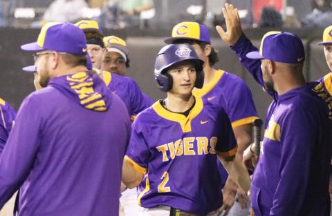 Columbia assistant coach Blake King high fives second baseman Madden Mann in the dugout after Mann scored the go-ahead run against Forest on Wednesday. (JORDAN KROEGER/Lake City Reporter) 