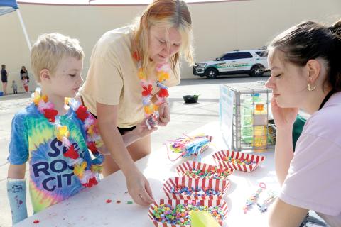 Ryan Poirier (clockwise from left), 6 and Callie Poirier make a bubble wand with help from Bella Heser during the MESS-tival event at the West Branch Library on Thursday morning. (TONY BRITT/Lake City Reporter)