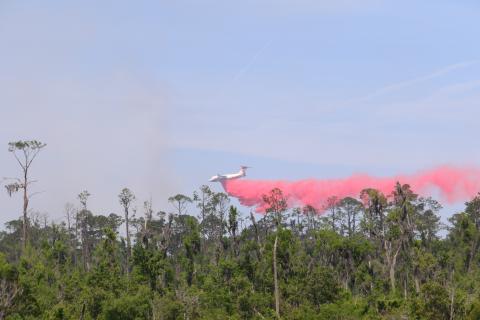A tanker drops fire retardant on the ongoing brushfire in the Osceola National Forest near the gun range on the northeast side of Lake City. (TONY BRITT/Lake City Reporter)