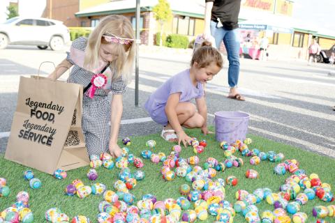 Riley Poirier (left), 8, and Kingsley Burnham, 4, look through Easter eggs at the Movement Mortgage Tent on Tuesday evening at the Texas Roadhouse Second Annual Easter Egg Hop event. (TONY BRITT/Lake City Reporter)