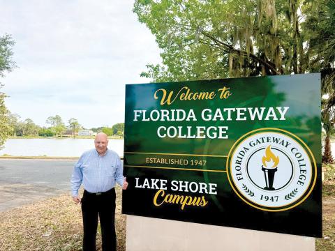 Florida Gateway College President Larry Barrett approves of the college’s new sign for its Lake Shore campus next to the former two-story women’s center building on the banks of Lake DeSoto in downtown Lake City. (COURTESY FLORIDA GATEWAY COLLEGE)