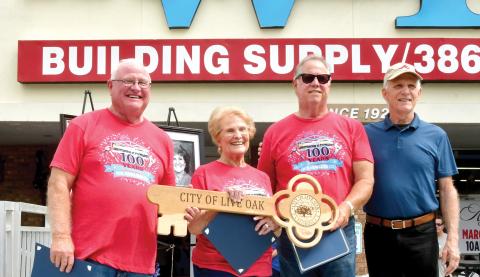 Live Oak Mayor Frank Davis (right) presented a key to the city to W.B. Howland Company owner Lyn Fletcher (second from right), Barbara Howland and Bill Howland during the company’s 100-year celebration Saturday. (ROB WOLFE/Lake City Reporter)