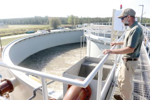 Cody Pridgeon, City of Lake City wastewater director, looks in on a tank of untreated wastewater at the North Florida Mega Industrial Park wastewater treatment plant last March shortly after it began operating. (FILE)