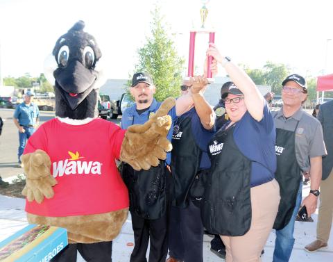 Wally the Goose presents representatives from the Lake City Police Department with a trophy after they defeated the Lake City Fire Department team in a hoagie-making challenge. (TONY BRITT/Lake City Reporter)