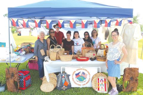 Members of the Filipino-American Cultural Society pose in their booth at last year’s Multi-Culutural Spring Market Festival near Darby Pavilion at Wilson Park. (FILE)