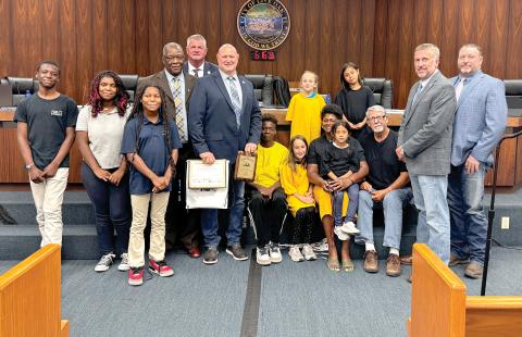 The Suwannee County Commission is pictured with Our Community Cares Coalition officials Bo Beauchemin and Befaithful Coker as well as children in the program. (JAMIE WACHTER/Lake City Reporter)