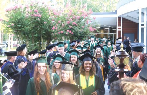 Florida Gateway College graduates file out of the Howard Center through columns of FGC  faculty and staff following a prior year’s graduation ceremony. (FILE)