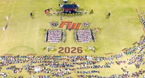 Family and friends surround the graduates on the field at Arrowhead Stadium on Friday night as Fort White High held its commencement ceremony for the Class of 2026. The ceremony was interrupted for about 45 minutes due to lightning in the area. (RAY CARPENTER/Lake City Reporter)