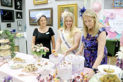 Karen Thurston (from left), Laney Grinstead and Laura Hunter Null, prepare snacks for women attending the ‘Hats Off To Mom’ fundraiser on Saturday at the Gateway Art Gallery. (TONY BRITT/Lake City Reporter)