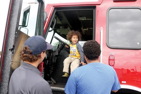 Kiler Simmons, 2, is excited about getting behind the steering wheel of a Lake City firetruck during the Kiwanis Kids Day on Saturday at the Florida Gateway Fairgrounds. (TONY BRITT/Lake City Reporter)