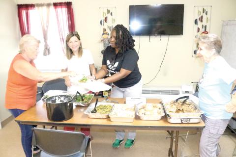 Trish Webb (from left), Roseanna Lee, Tanzania Williams and Bonnie Page prepare to-go plates for veterans who reside in the Lake City Cabins for Veterans on Friday afternoon. The Columbia County Executive Committee provides the lunches, free, on the last Friday of every month. (TONY BRITT/Lake City Reporter)