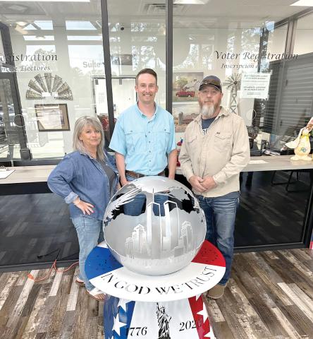 Rhonda Anderson (from left) stands with Kent Banner, Columbia County Assistant Supervisor of Elections, and Darryl Thomas, Columbia High School welding instructor, as the school’s welding piece, ‘Globe of Freedom,’ is on display at the Columbia County Supervisor of Elections Office. (COURTESY)