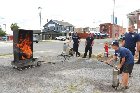 Easton Starling, 11, utilizes training he learned at a Lake City Fire Department summer camp to douse flames with a fire extinguisher. (TONY BRITT/Lake City Reporter)