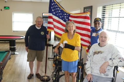 U.S. Army veterans John “Dutch” Shultz (foreground from left), Dawn Huston and Terry Holliday pose for a Flag Day photograph as  Kenneth Burkes, an American Legion member, holds the flag. (TONY BRITT/Lake City Reporter)