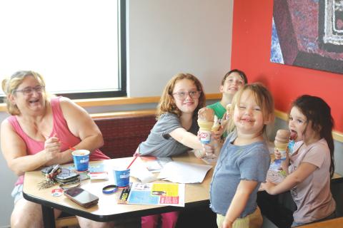 Bralen Peavy (foreground), 2, flashes a smile with chocolate on her face as she and Nevaeh Peavy (far right), 3, enjoy a cone of ice cream during the Cops-N-Cones event on Tuesday afternoon at Dairy Queen. (TONY BRITT/Lake City Reporter)