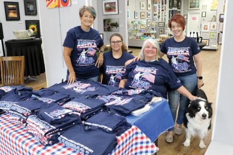 Lisa Amparo (from left), Mikael Byrd, Kathy Olson, Shelia Carr and Cooper take pose for a photo with the 250th anniversary celebration T-shirts while at the Gateway Art Gallery on Tuesday afternoon. The T-shirts are for sale at $10 each. (TONY BRITT/Lake City Reporter)