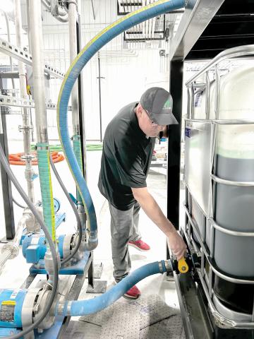 AgroLiquid site manager Jeff Herald prepares ingredients inside the Lake City facility. (COURTESY AGROLIQUID)