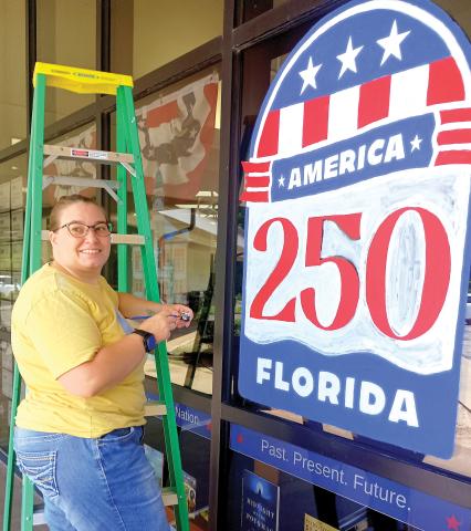 Artist Maggie Wilburn finishes up her America 250 art work on the Suwannee River Regional Library’s Live Oak branch ahead of the July 4 holiday. (ROB WOLFE/Lake City Reporter)