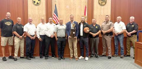 Columbia County Clerk of Court Jay Swisher holds the Boots and Badges championship trophy ahead of this year’s tournament. The Legal Eagles, representing attorneys at the courthouse, are the defending champions. (COURTESY)