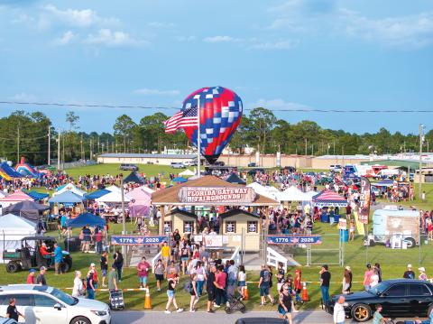 A hot air balloon stands ready behind an American flag as part of the 250th anniversary celebration of the United States of America on Saturday at the Florida Gateway Fairgrounds. The hot air balloons, though, were unable to fly due to windy conditions. The celebration attracted more than 7,000 to the fairgrounds. (RAY CARPENTER/Lake City Reporter)