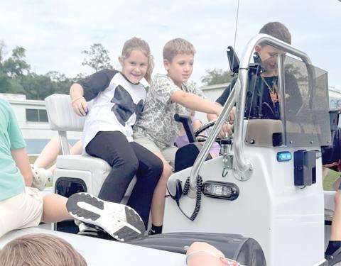 Campers checking out the Florida Wildlife Commission boat while learning about boating safety. (COURTESY LAFAYETTE COUNTY 4-H)
