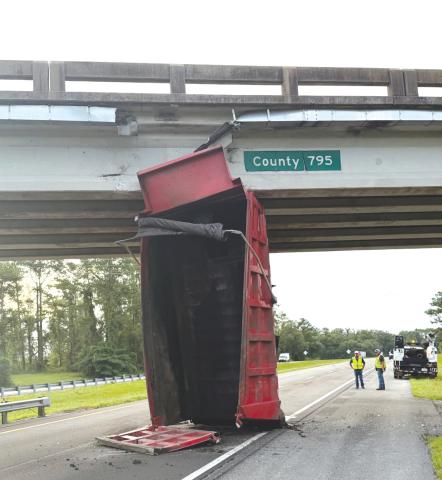 A dump truck’s bed sits in the eastbound lanes of Interstate 10 after hitting the County Road 795 overpass on Monday. (COURTESY FHP)