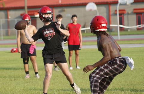 Lafayette quarterback Tucker Higginbotham throws a pass while being rushed by defensive end Zamarion Hawkins during Tuesday’s practice. (JAMIE WACHTER/Lake City Reporter)