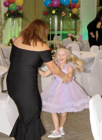 A child laughs while dancing at the inaugural Laced Up for Love Sneaker Ball last year. (COURTESY)