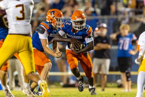 Branford quarterback Trent Land hands the ball off the running back Ollie James on Friday. (JACK HOWDESHELL/Lake City Reporter)