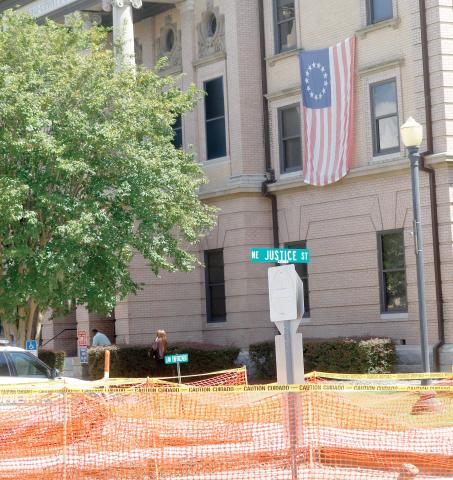 Orange construction fencing sits outside the Columbia County Courthouse, which is undergoing an exterior revitalization project. (JAMIE WACHTER/Lake City Reporter)