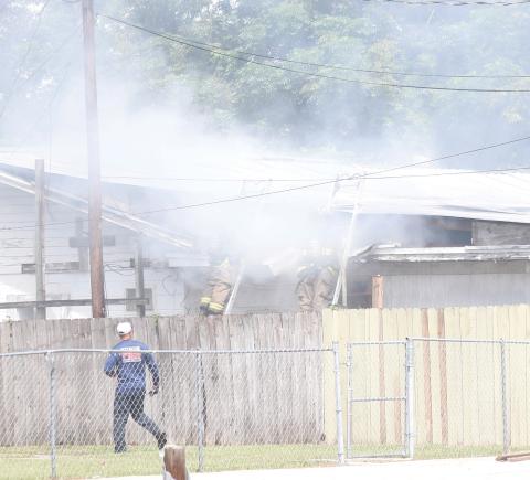 Lake City firefighters combat a fire in an attic space of a house on NW Burk Avenue late Thursday morning. (JAMIE WACHTER/Lake City Reporter)
