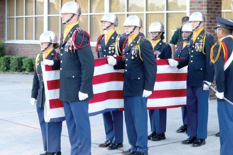 Columbia High JROTC cadets hold the American flag in front of the school Friday morning as they ready to raise it during the program’s annual 9/11 Memorial March. (TONY BRITT/Lake City Reporter)