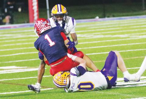 Columbia defensive back Mekah Combs-Turner (back) and linebacker Bryson Grinstead (bottom) combine to tackle Manatee receiver Deno Dalacas on Oct. 2. (JORDAN KROEGER/Lake City Reporter)