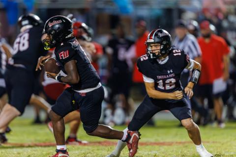 Fort White quarterback Carter Wheeler (12) hands the ball off to running back John’l Lawson during last week’s 29-22 win over Lafayette. (JACK HOWDESHELL/Lake City Reporter)