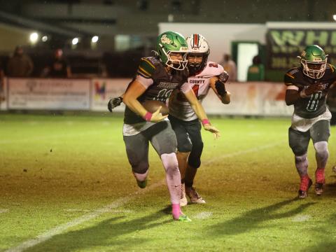 Suwannee quarterback Haigen Johnson tries to scramble away from Baker County defensive end Joshua Chick on Friday night. Chick sacked Johnson on the play. (PAUL BUCHANAN/Lake City Reporter)
