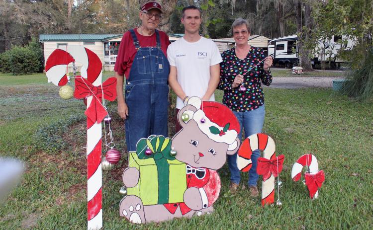 Callahan’s Fred Heinrich, son William Heinrich, Jr. and fiancée Cheryl Hodge stand near one of the themed creations that are on display in their yard on Old Dixie Highway in Callahan.
