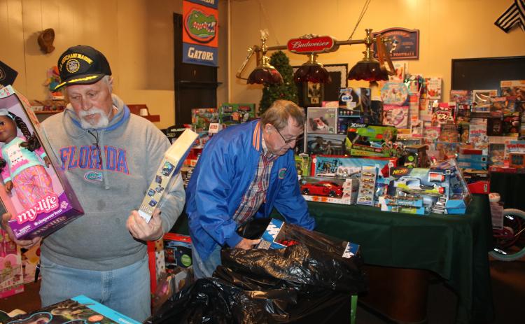 Lake City Elk Club 893 members Michael Lydick (left) and Larry Ward work on arranging toys Thursday afternoon as they prepare for the annual Elks Club Children’s Christmas Party, which will take place at about 5 p.m. on Christmas Eve. (TONY BRITT/Lake City Reporter)