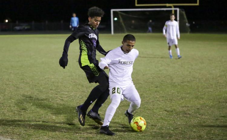 Columbia’s Ismael Cisse chases down possession from Forest’s Gavin Palawski on Tuesday night. (BRENT KUYKENDALL/Lake City Reporter)