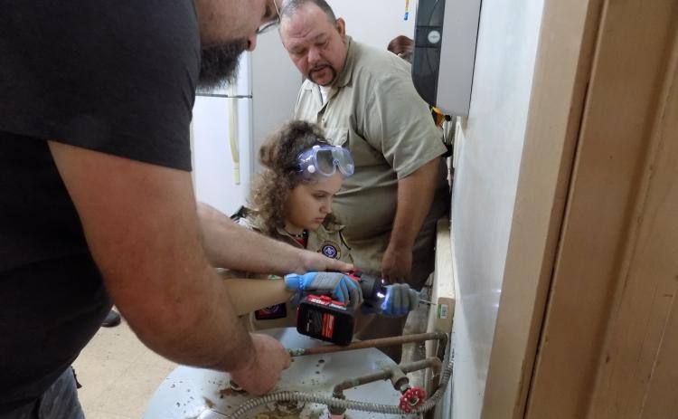Jayson Wolff helps Skylar Beichner guide in a screw for a shelf as Tom Mullers, the scout master for Troop 85, the boys’ troop, looks on. Under rules put into effect last year, girls can form their own troops in the Boy Scouts, now known as BSA. (STEPHANIE CHAMBERS-WOLFF/Special to the Reporter)