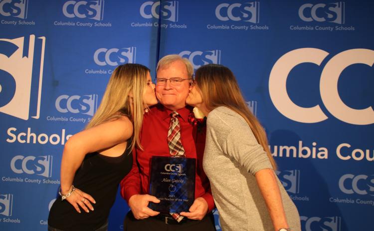 Megan Gatzke (left), gives her father, Alan Gatzke, a kiss on the check at the same time as her mother, Mary Gatzke. (TONY BRITT/Lake City Reporter)