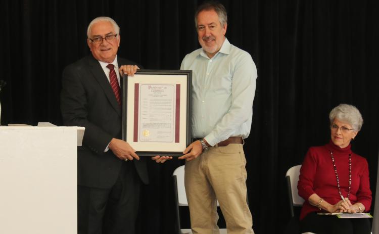 Mayor Stephen Witt presents Kevin Cheek with a copy of the proclamation honoring him on Arbor Day for his efforts beautifying Columbia County. (MICHAEL PHILIPS/Lake City Reporter)