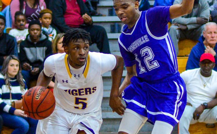Columbia guard Darrien Jones drives by Gainesville’s Alex McCray on Tuesday night. (THOMAS RICKS/Special to the Reporter)