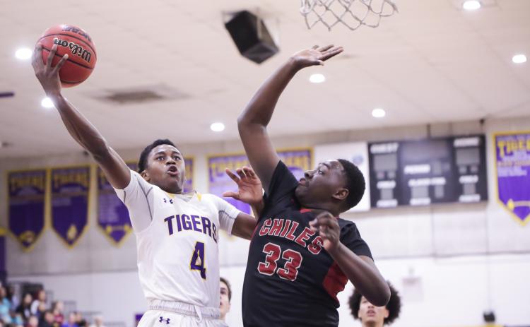 Columbia guard Kenney Gaines gets past Chiles forward Burl Gaskins for a layup during Thursday's Region 1-6A quarterfinal. (BRENT KUYKENDALL/Lake City Reporter)