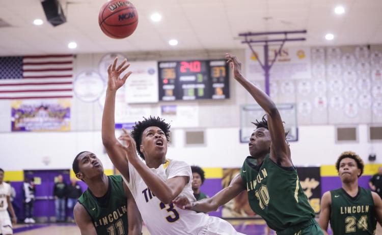 Columbia forward Charleston Ponds puts up a shot between Lincoln's Perry Fisher (11) and Jordan Wilford (10) during Tuesday night's Region 1-6A semifinal. (BRENT KUYKENDALL/Lake City Reporter)