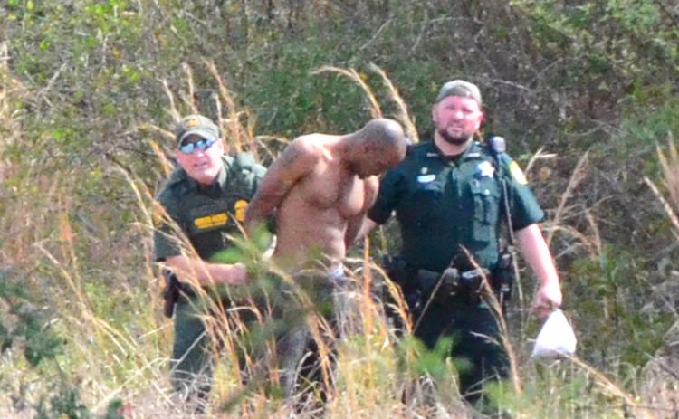 Suspect Breon Walker, 29, is led to a waiting cruiser after being apprehended by deputies. (CARL MCKINNEY/Lake City Reporter)
