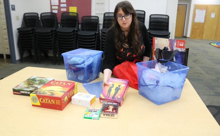 Emma Miles, Columbia County Library programs specialist, unpacks board and table-top games that will be featured in the library’s inaugural Teen Gaming League Night, set for 4-5 p.m. Wednesday. (TONY BRITT/Lake City Reporter)