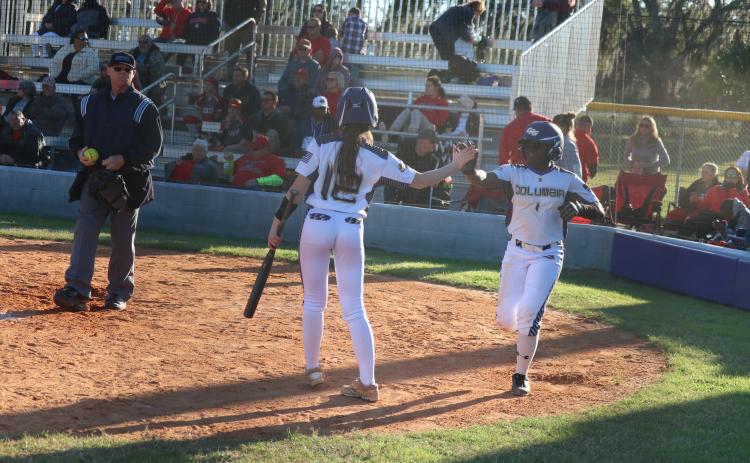 Columbia’s Anissa Penniman (12) high fives Zoryana Hughes after Hughes scored the game-winning run on a passed ball against Lafayette on Friday. (JORDAN KROEGER/Lake City Reporter)