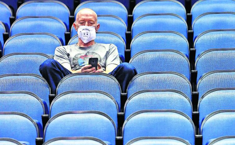 Mike Lemcke, from Richmond, Va., sits in an empty Greensboro Coliseum after the games were canceled at the Atlantic Coast Conference basketball tournament in Greensboro, N.C. (BEN McKEOWN/Associated Press)